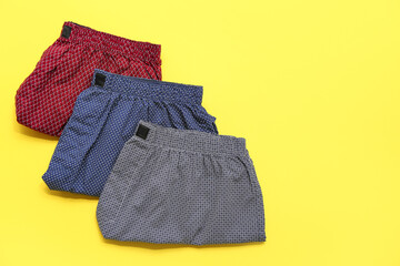 Stylish male trunks on yellow background