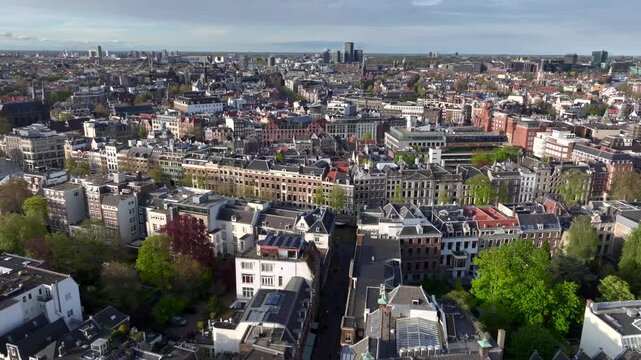 Historical Center of Amsterdam, Netherlands. Aerial Drone Shot of Traditional Dutch houses on narrow street and channel.