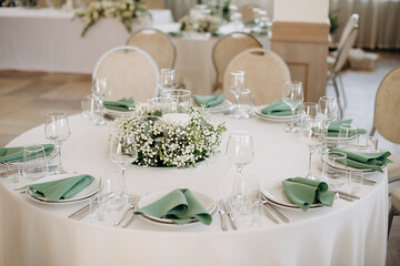 A round table set with elegant glassware and floral centerpieces in an event setting
