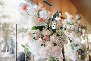 A vibrant floral arrangement featuring white and pink roses, gerberas, hydrangeas, and gypsophila...