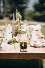 Outdoor table setting with moss decor and number four. Natural, bright atmosphere