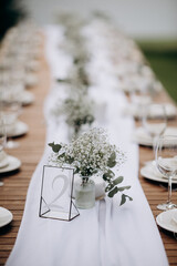Outdoor table setting with gypsophila and number two. Natural, elegant atmosphere