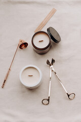 A collection of wooden wick candles along with candle-making and usage accessories, including wick trimmers, a candle snuffer, and matches