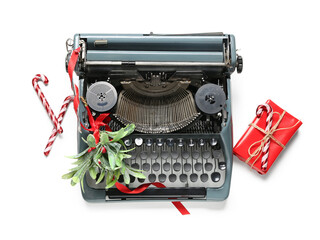Vintage typewriter with mistletoe, candy canes and gift box on white background. Top view