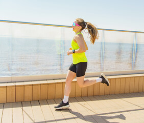 Vibrant Runner Enjoys a Sunny Workout Along the Waterfront Promenade on a Bright Spring Day