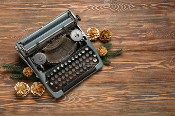 Vintage typewriter with pine cones and Christmas tree branches on wooden background