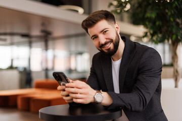 Businessman take a break from work and use mobile phone and smile in modern office
