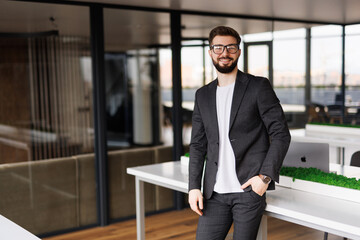 Fototapeta premium Businessman posing confident and positive at workplace office with space