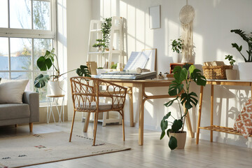 Interior of light living room with synthesizer, shelf unit and plants