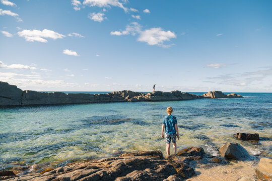 Kids enjoying The Tanks natural tourist attraction at Forster on bright summer day