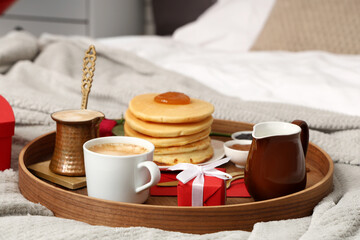 Tray with breakfast and gift for Valentine's Day on plaid, closeup