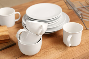 Set of clean ceramic dishes on wooden kitchen counter