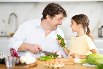 Father and daughter cooking in kitchen