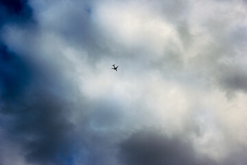 airplane flying high in the cloudy sky
