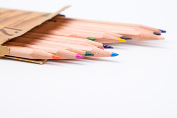 Colored pencils in a box on a white background close up