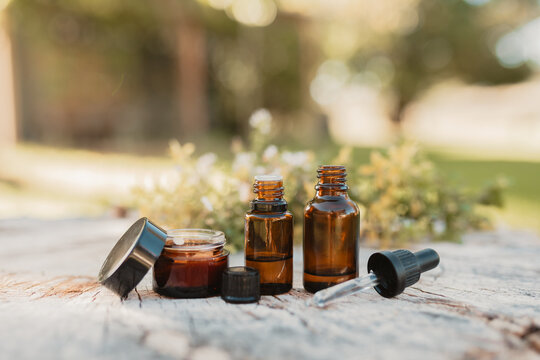 Various amber essential oil bottles in natural outdoor setting