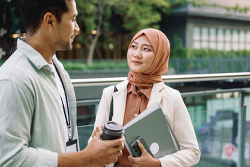 Business partners having informal conversation outdoors during coffee break