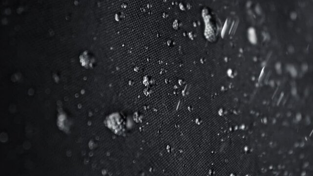 Super Slow Motion Detail Shot of Water Flow Down on Waterproof Black Cloth at 1000fps.
