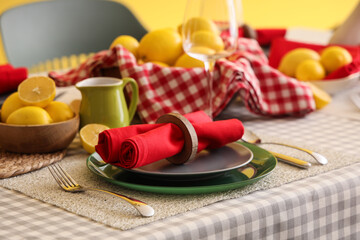 Stylish table setting decorated with many fresh lemons in dining room
