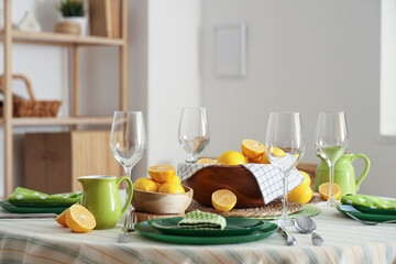 Stylish table setting decorated with many fresh lemons in dining room
