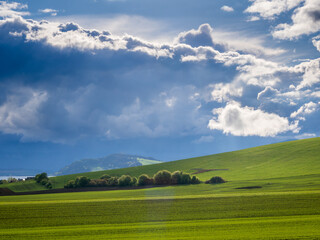 Mountain landscape. A view of the green hills with storm clouds looming over them.