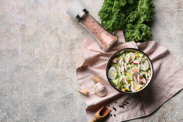 Bowl of salad with crab sticks, iceberg leaves, corn, cucumber and quail eggs on grey grunge background © Pixel-Shot