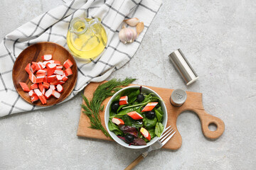 Bowl of salad with crab sticks, spinach, black olives and ingredients on grey grunge background © Pixel-Shot