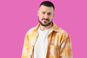 Apologetic young man on violet background
