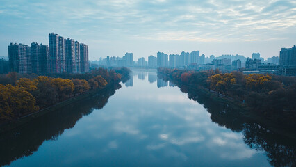 Fototapeta premium Aerial drone view of a city skyline reflected in a calm river