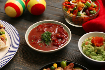 Traditional Mexican food and maracas on black wooden background, closeup. Cinco de Mayo (Fifth of May) celebration