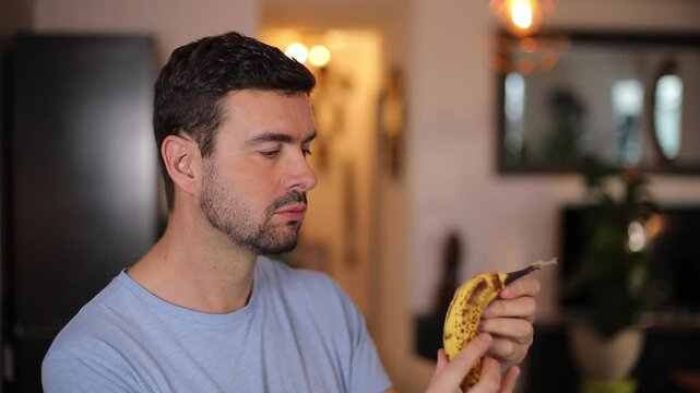 Handsome man eating a banana 