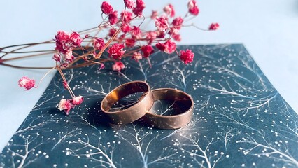 Elegant wedding rings with dried gypsophila flowers on a decorative background, symbol of love and...