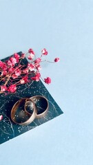 Elegant wedding rings with dried gypsophila flowers on a decorative background, symbol of love and...