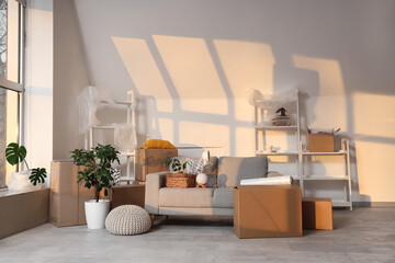 Fototapeta premium Empty living room with moving boxes and furniture, relocation and home transition concept, new apartment interior