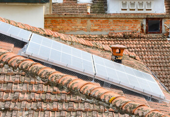 Solar panels with bird protection net on a tiled roof