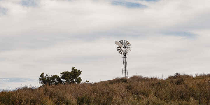 Rural Australian country scene with windmill on hill top