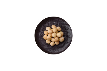 Raw peeled macadamia nut in ceramic bowl