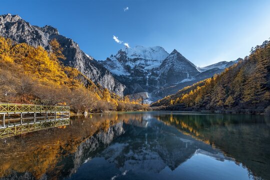 Stunning autumn landscape at Yading Nature Reserve, China with snow-capped mountains.