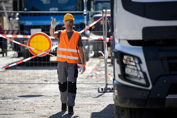 Construction worker directing traffic at a busy construction site during daylight hours