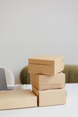 Stacked brown boxes on a white table in a minimalist workspace ready for shipping or delivery preparation