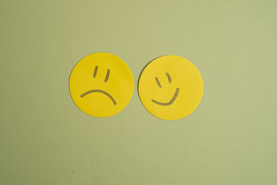 Naklejki Paper cut smiley face, sad face, happy smiley face on color background. Bipolar disorder and depression, mental health concept, personality, mood swings, therapeutic healing concept