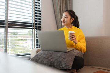 Fototapeta premium a woman is spending her holiday in the living room of her house, feeling peaceful and happy because she has done many activities that make her feel relaxed, lifestyle, apartment, sofa, couch