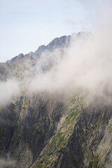 Mountain side with low clouds and light blue sky background, High Tatra mountains, Slovakia