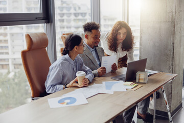 A diverse team is strategically collaborating on data and analytics in a stylish office, brainstorming creatively