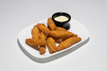 Crispy Breaded Chicken Fingers Served with Creamy Dipping Sauce on a White Plate