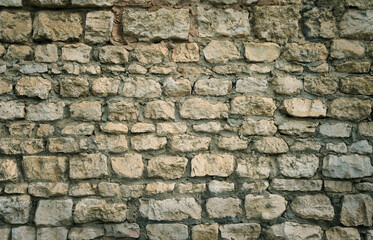 Texture of old stone wall background close up. fragment of dark beige-gray color decorative stone wall surface. 