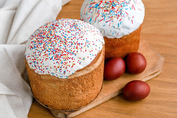 Easter holiday food.Homemade Easter cake with white icing, sweet powder,decorated with colored eggs on wooden background.