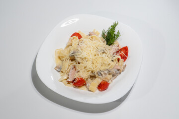 Creamy Pasta with Chicken, Cherry Tomatoes and Parmesan garnished with Dill on White Plate