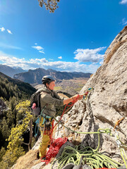 A Woman Climbing a Multipitch in the Bavarian Alps and Reaching the Stand: A Tangle of Ropes and...