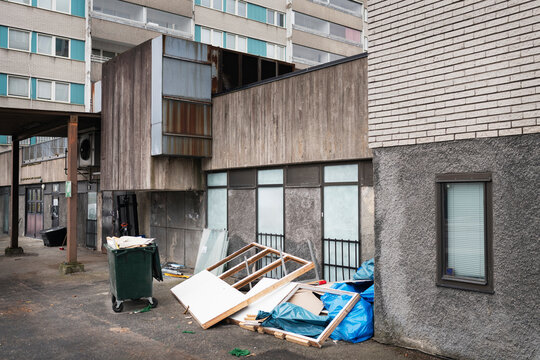 Broken wooden frames and garbage on pavement